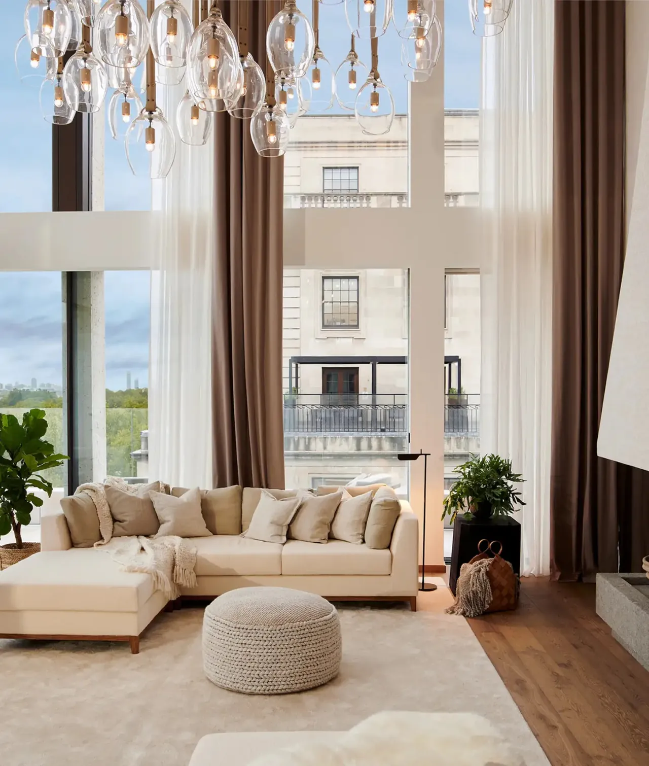 The penthouse living room with a crystal chandelier and a large sofa.