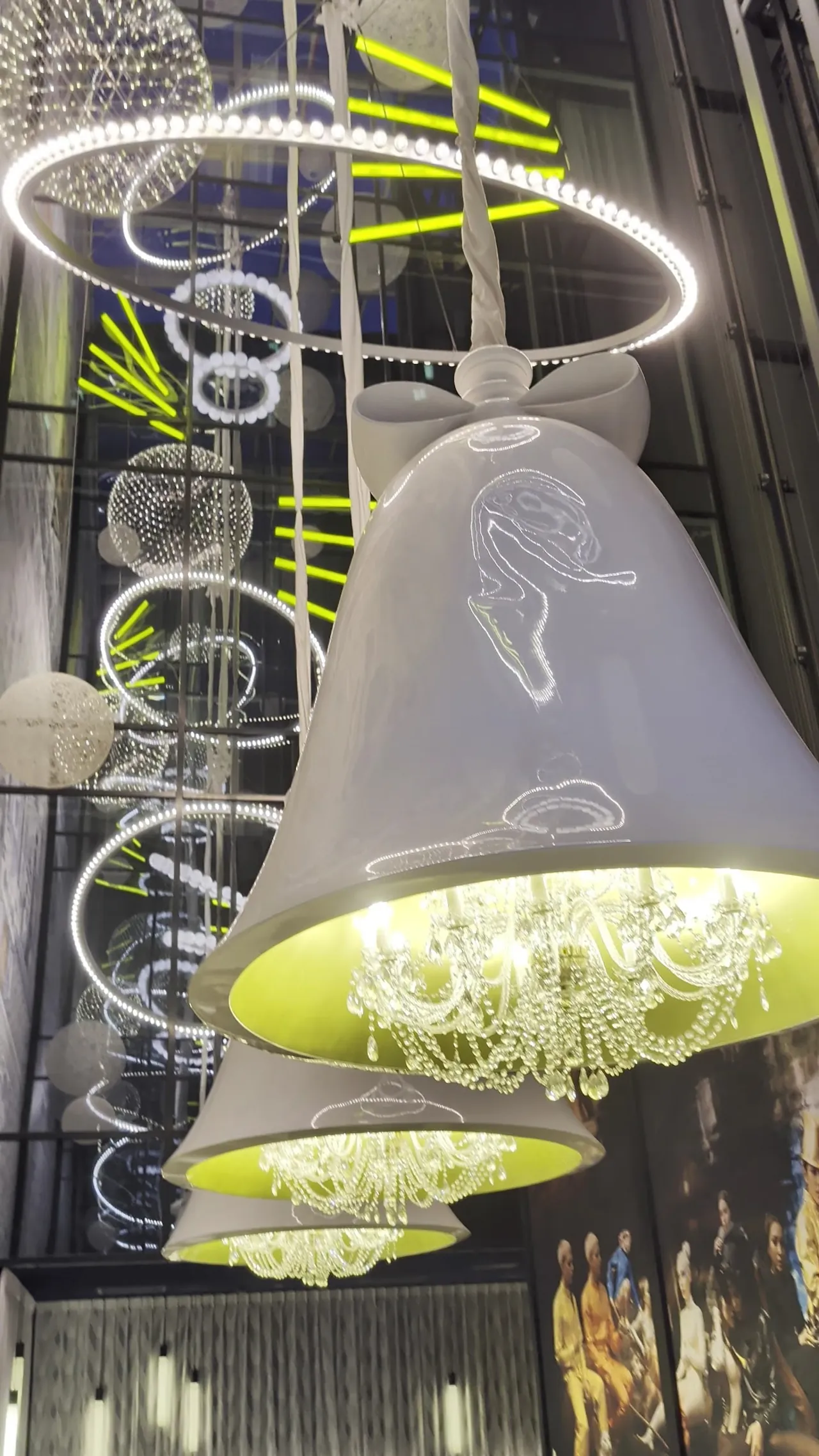 Oversized white bell lamps hang from a glowing ring inside the hotel.
