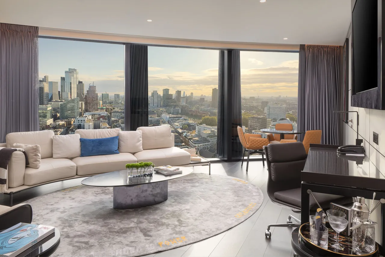 A suite living room with floor-to-ceiling windows over the London skyline.