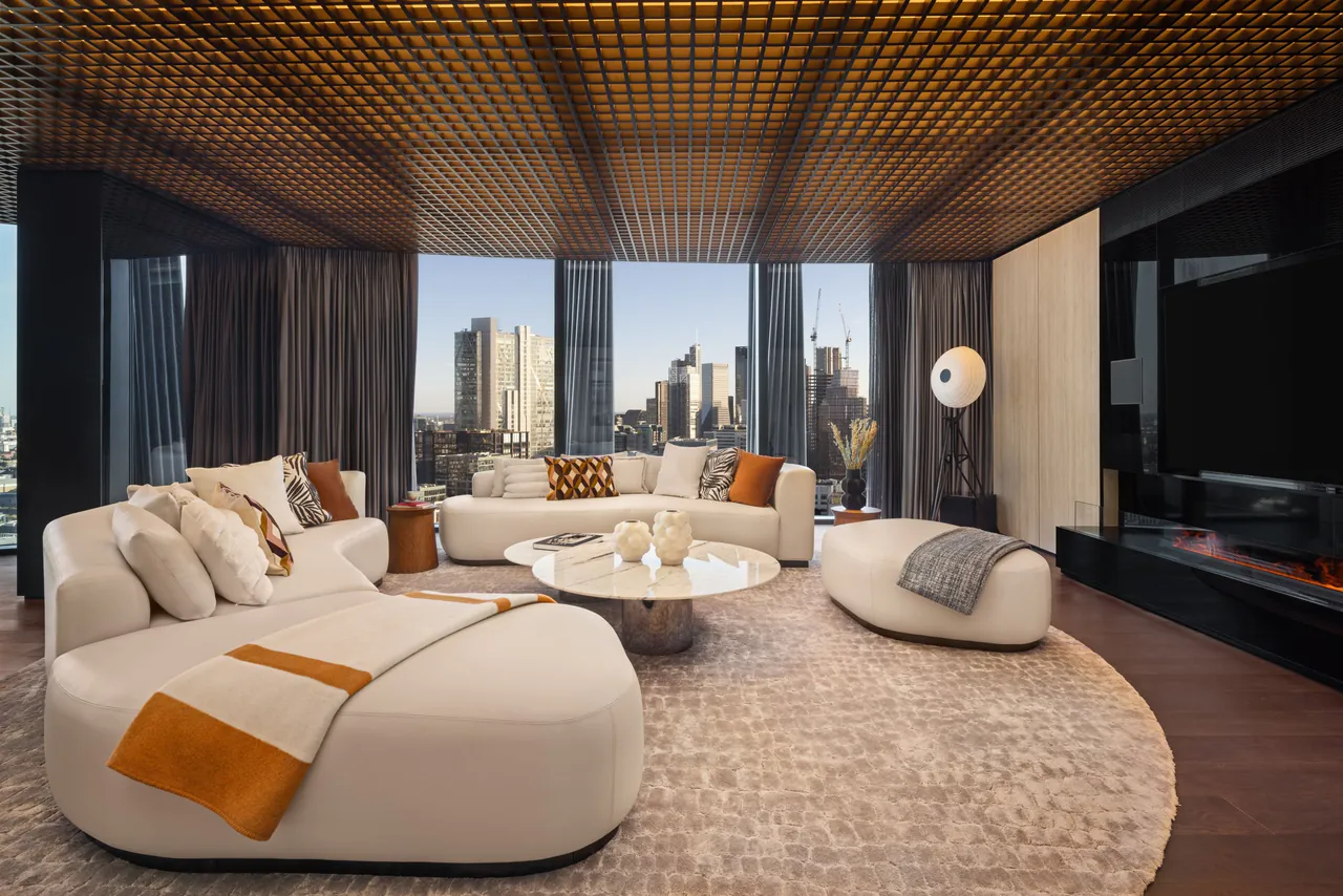 The Masterpiece Suite with a curved cream sofa and city views.