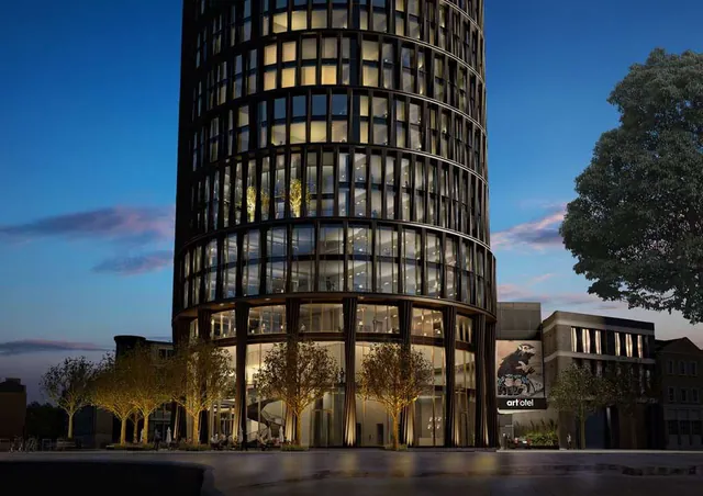 The dark cylindrical tower of art'otel London Hoxton at dusk.