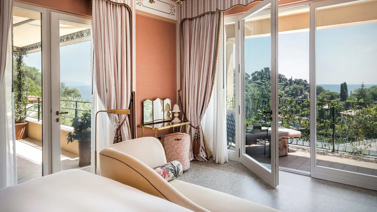 The Baronessa Suite in soft pink, with windows on two sides over the garden.