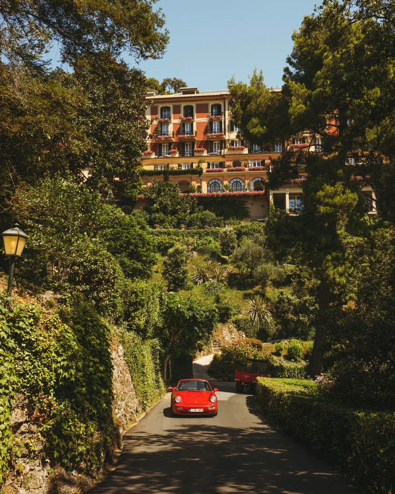 A red vintage car on the winding drive up through the trees to the hotel.
