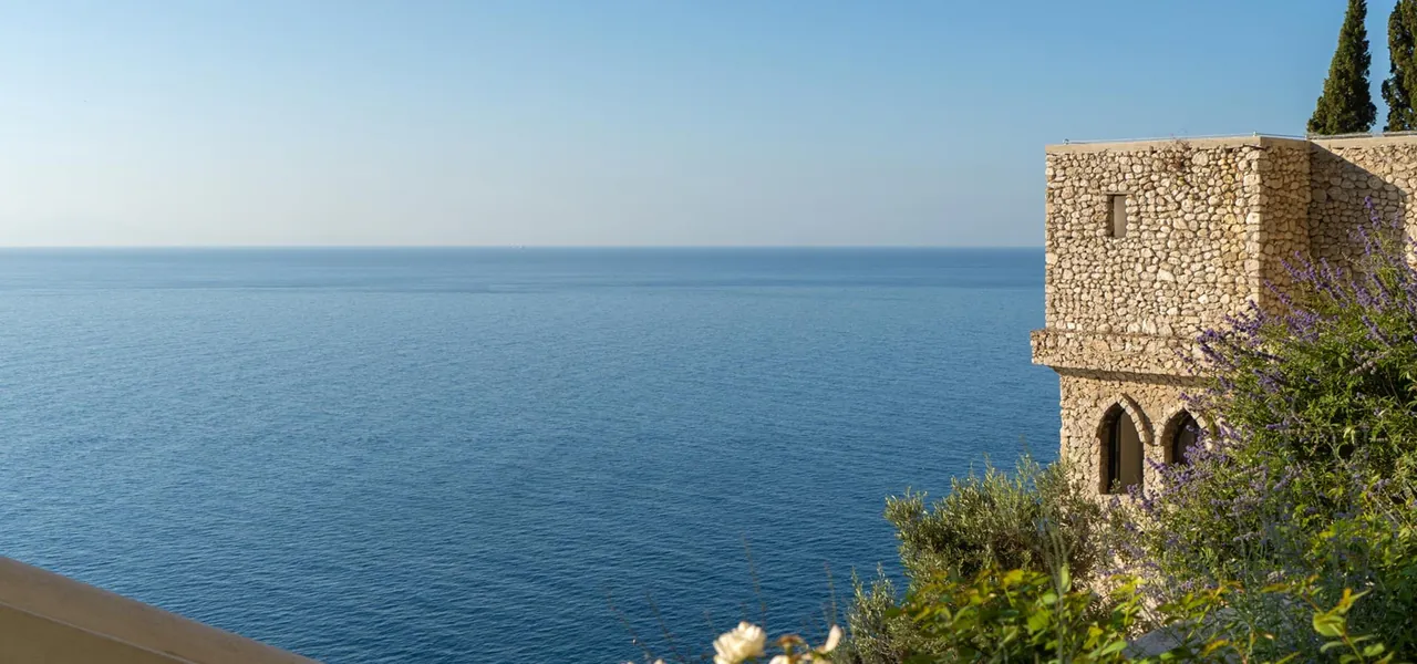 A stone watchtower above a calm, open sea.