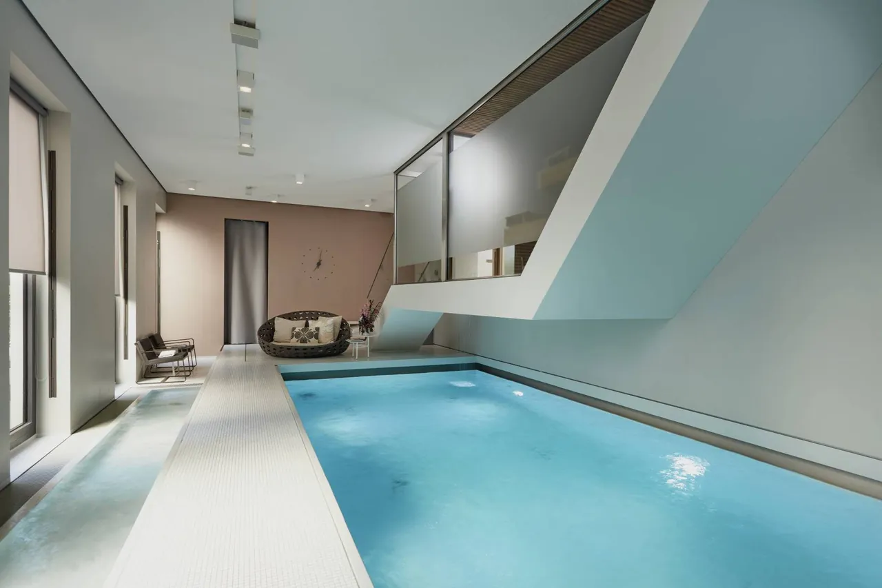 The slim indoor pool in the hotel spa with clean white architecture.