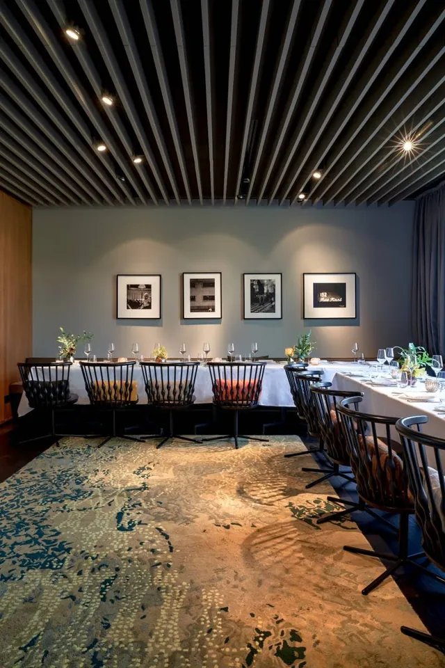 The private dining room with a long table under framed photographs.