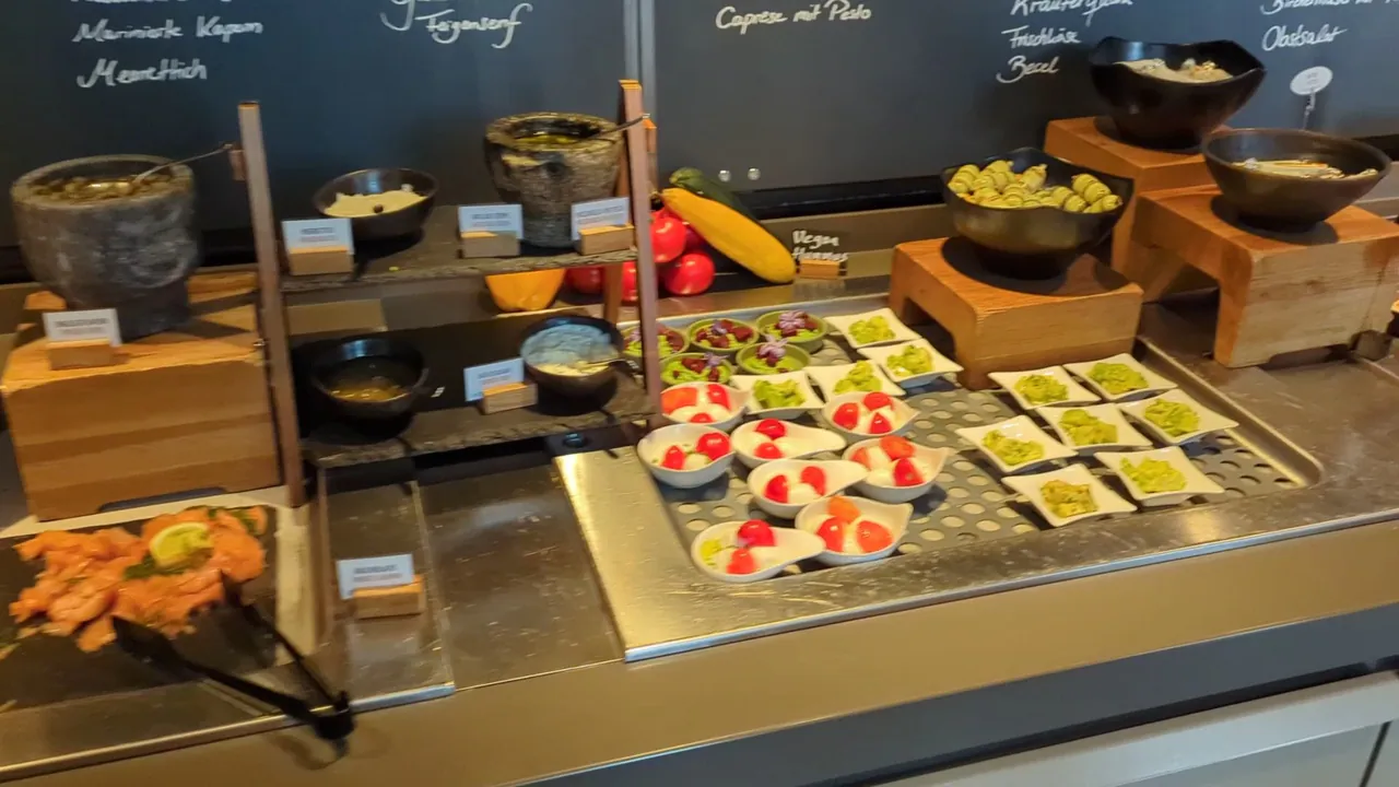 A breakfast buffet with fresh fruit, pastries and small dishes.