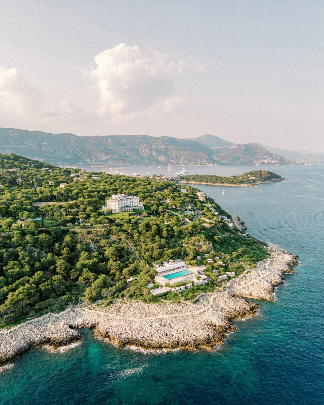 Aerial view of Cap-Ferrat, with the hotel among the pines and its pool on the rocks below.