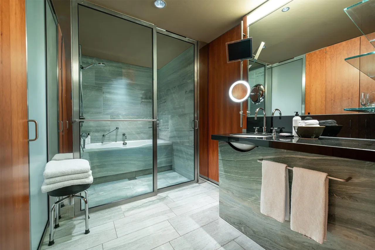 Bathroom with a glass shower, a bathtub and a wooden vanity.