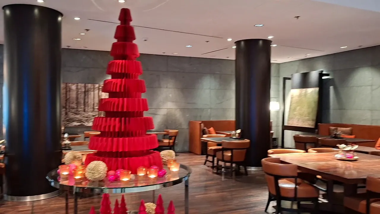 Lounge with leather seating and a tall red macaron tower.