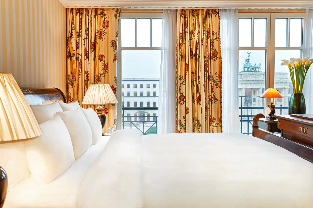 A guest room with a large bed and a view of the Brandenburg Gate.