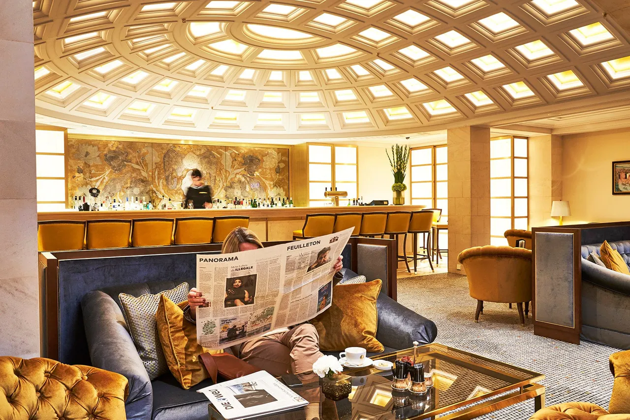 The lobby lounge beneath a glass dome with armchairs and a bar.