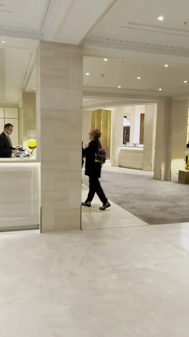 A guest walks through the bright marble lobby of the hotel.