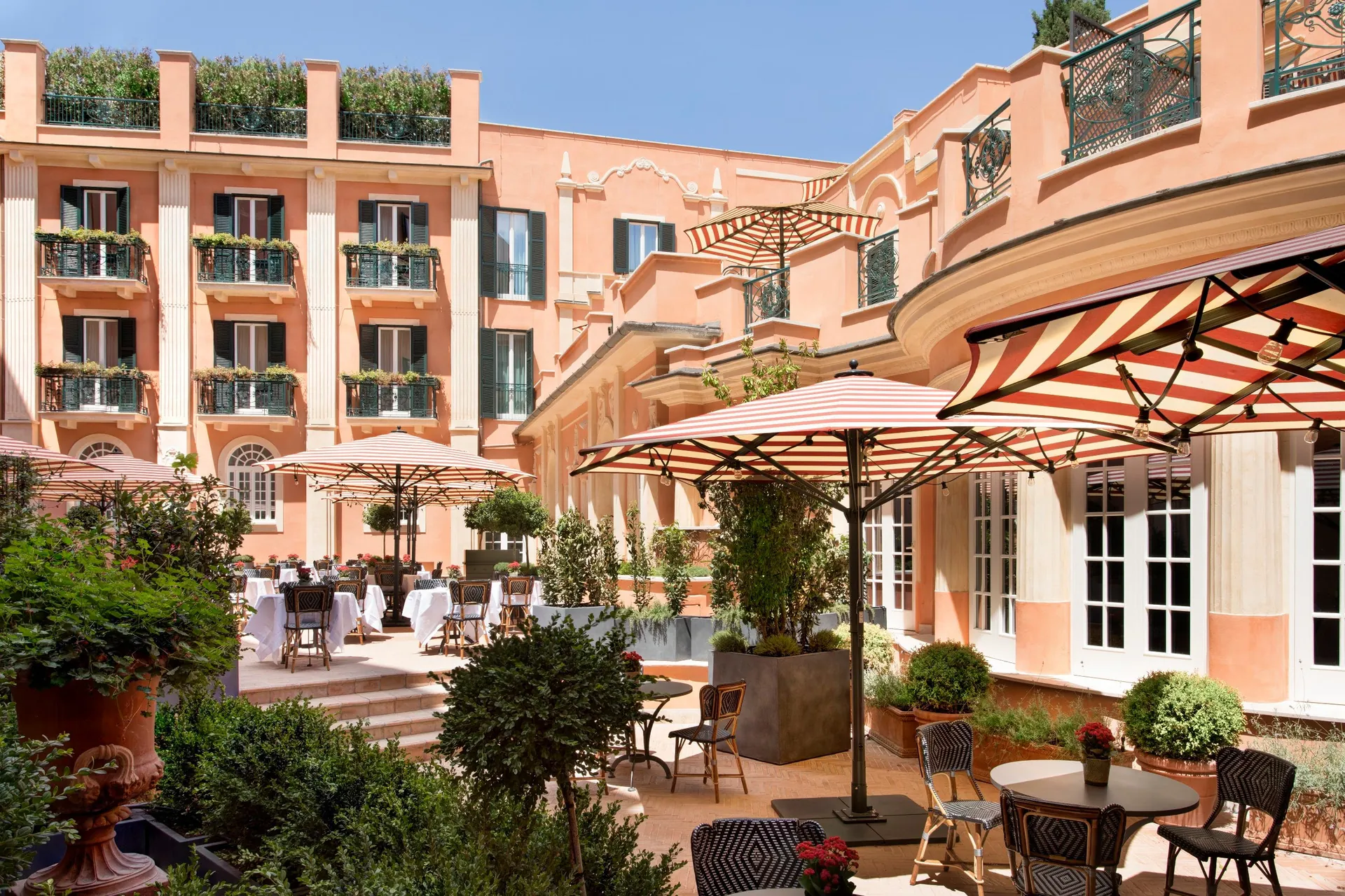 The terracotta courtyard garden with striped awnings and outdoor tables.