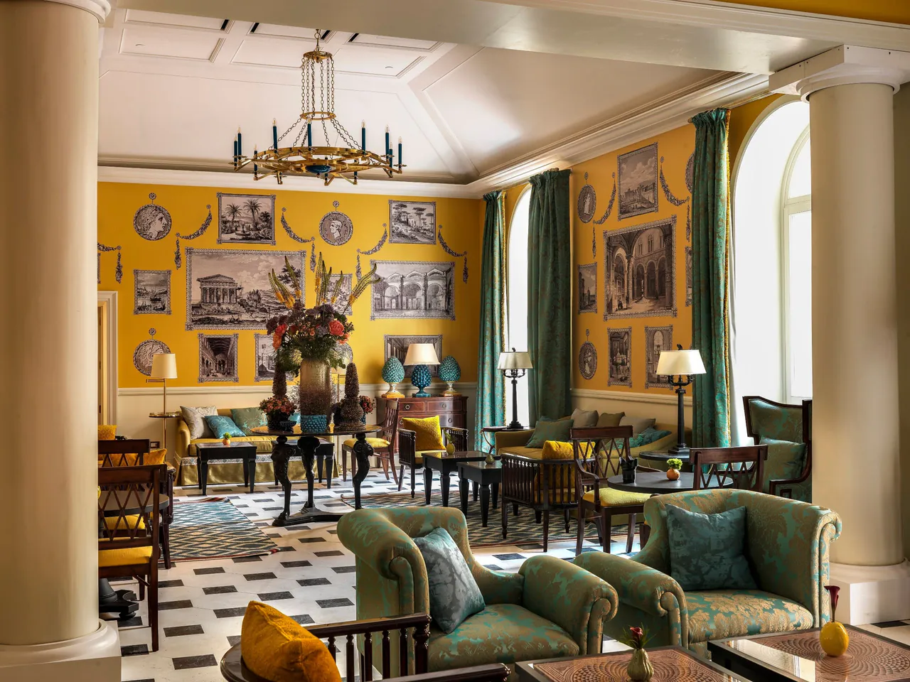 A saffron yellow lounge with green sofas, columns and a chequered floor.