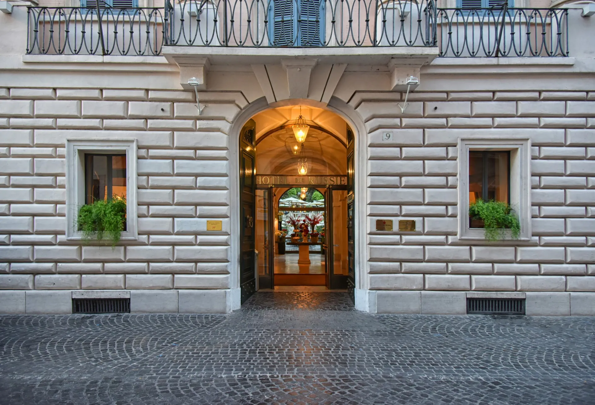 The arched entrance of Hotel de Russie in its stone facade on Via del Babuino.