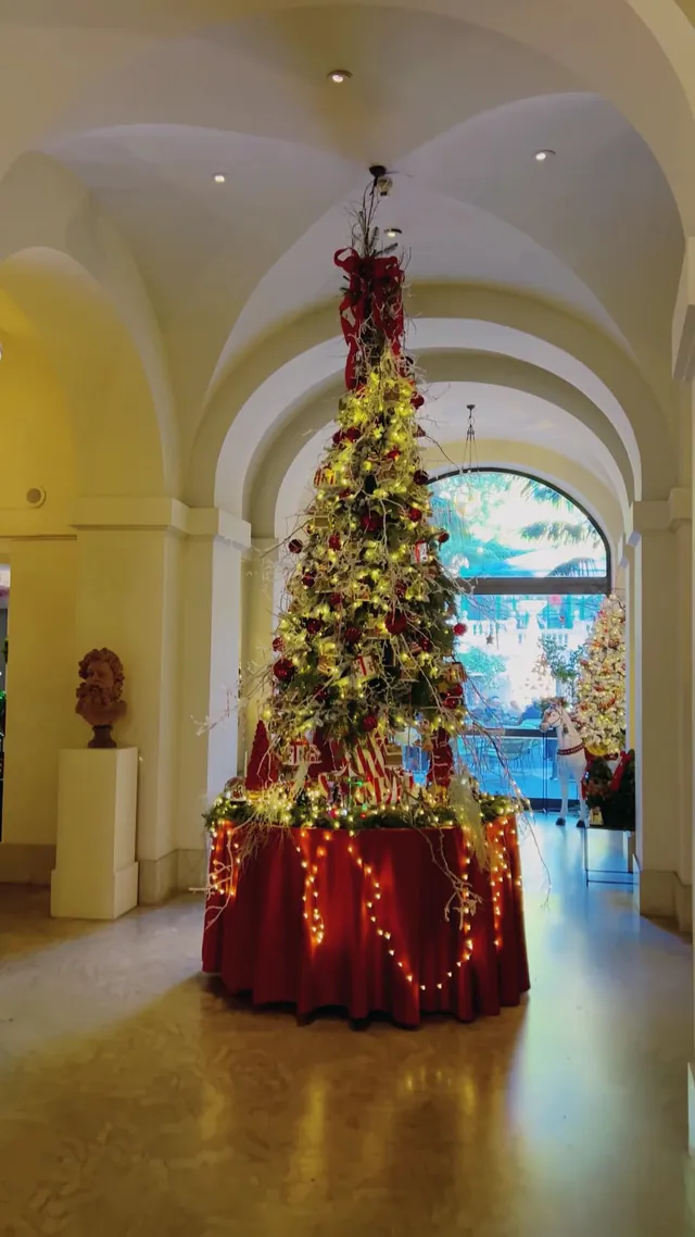 A tall Christmas tree in the vaulted hallway of the hotel.
