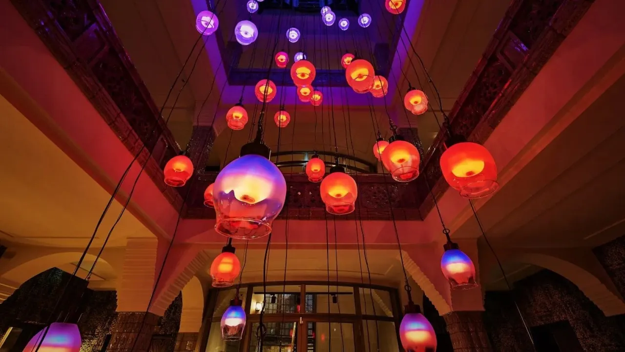 Colourful glass lanterns hang from a red lounge ceiling.