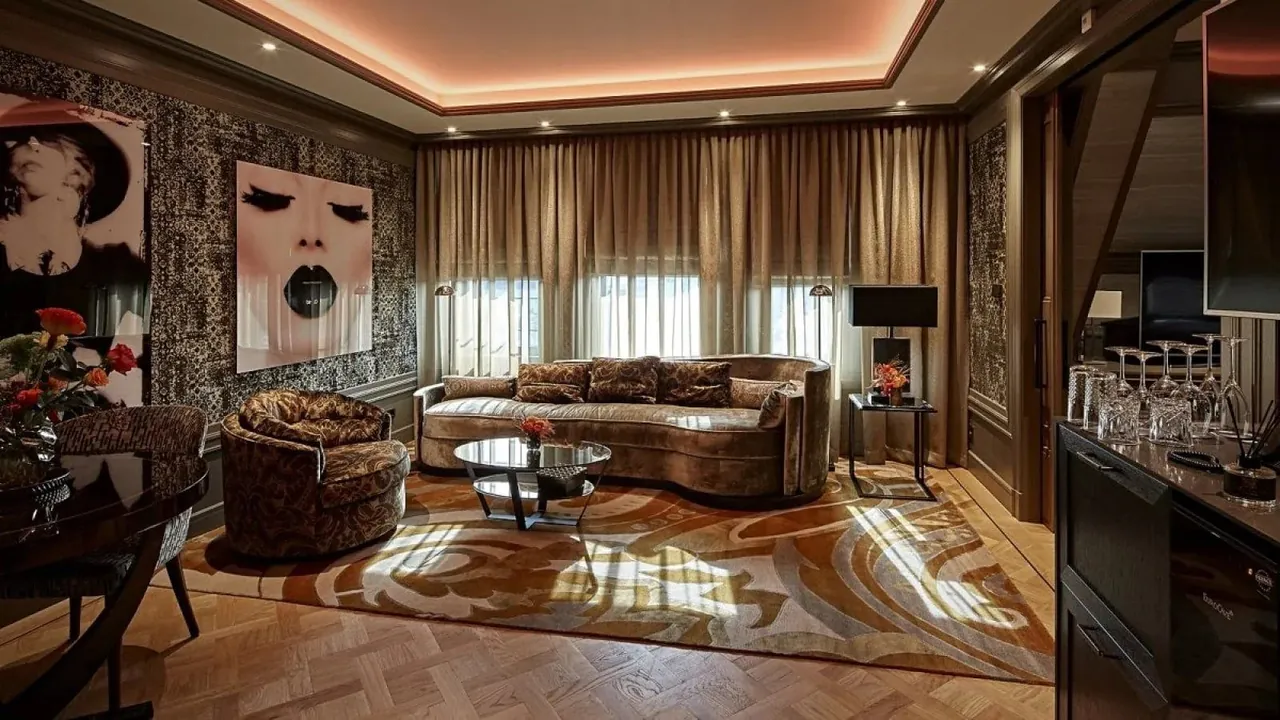 A suite living room with patterned walls, plush sofas and a large portrait.