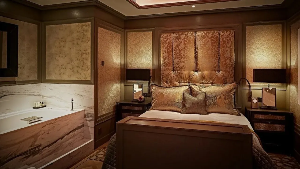 A bedroom with a whirlpool tub set beside the bed.