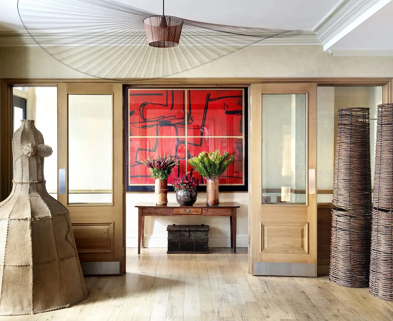Bright hotel lobby with a red artwork, a stone sculpture and fresh tulips.