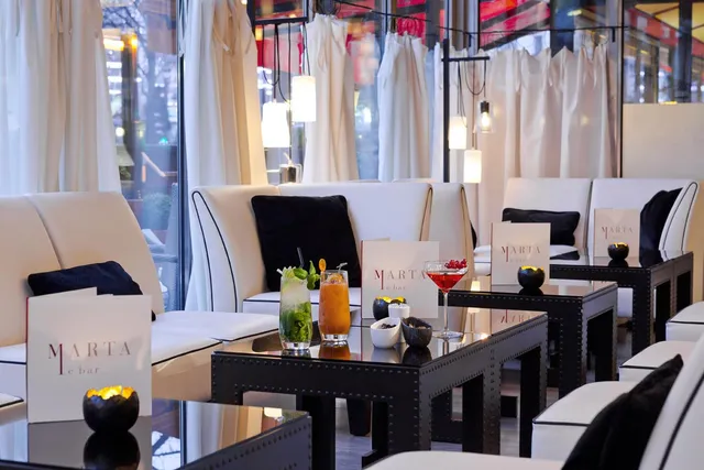 Marta bar at Le Fouquet's Barriere, Paris, with white banquettes, black tables and colourful cocktails