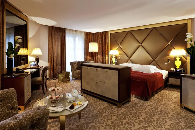 Suite at Le Fouquet's Barriere, Paris, with a quilted headboard, writing desk and afternoon tea table