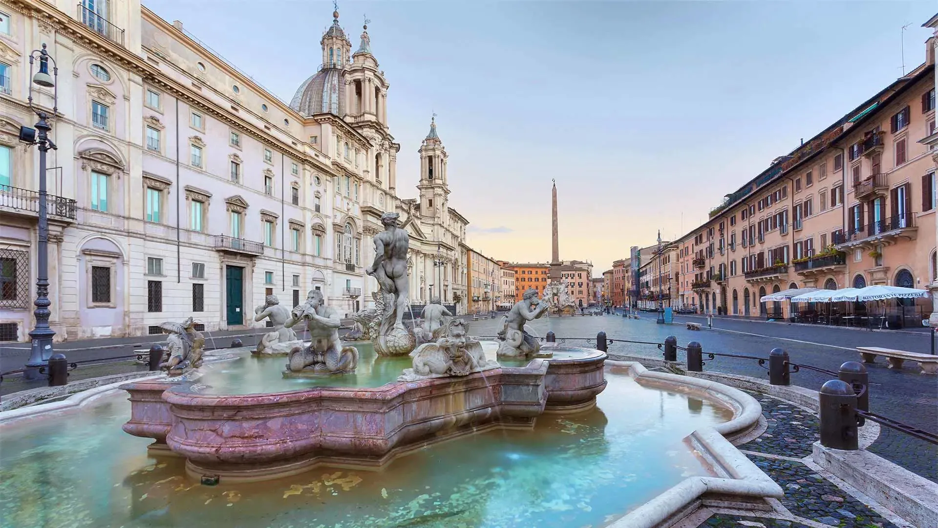 Piazza Navona with its fountains and baroque church on a sunny morning.