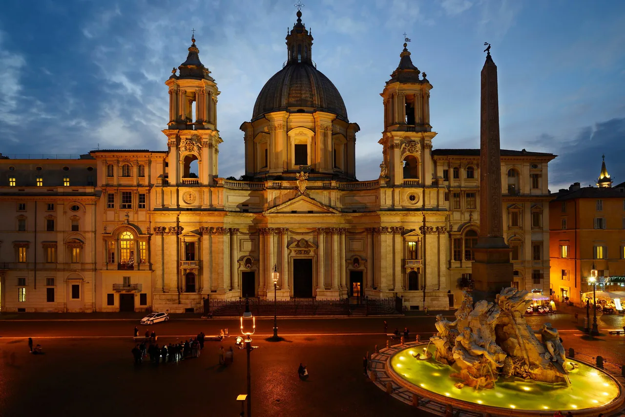 Sant'Agnese in Agone and the fountain lit up at night.