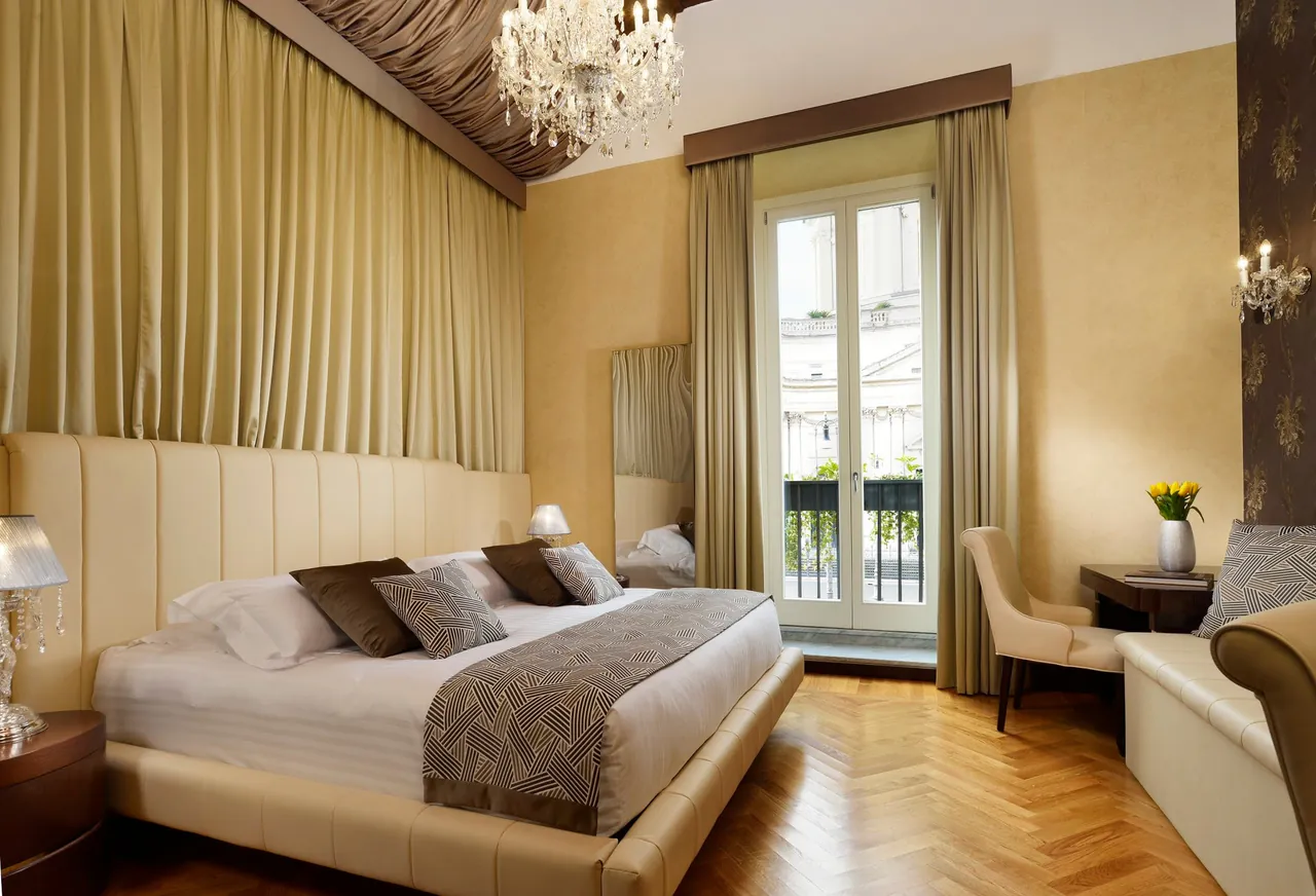 Bright suite with a chandelier, cream walls and a balcony door.