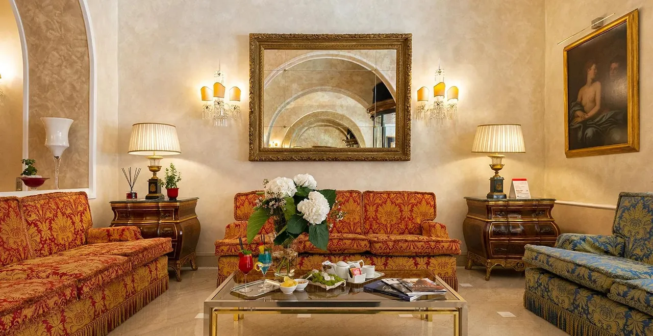 A classic lounge with gilded mirrors and red damask sofas.