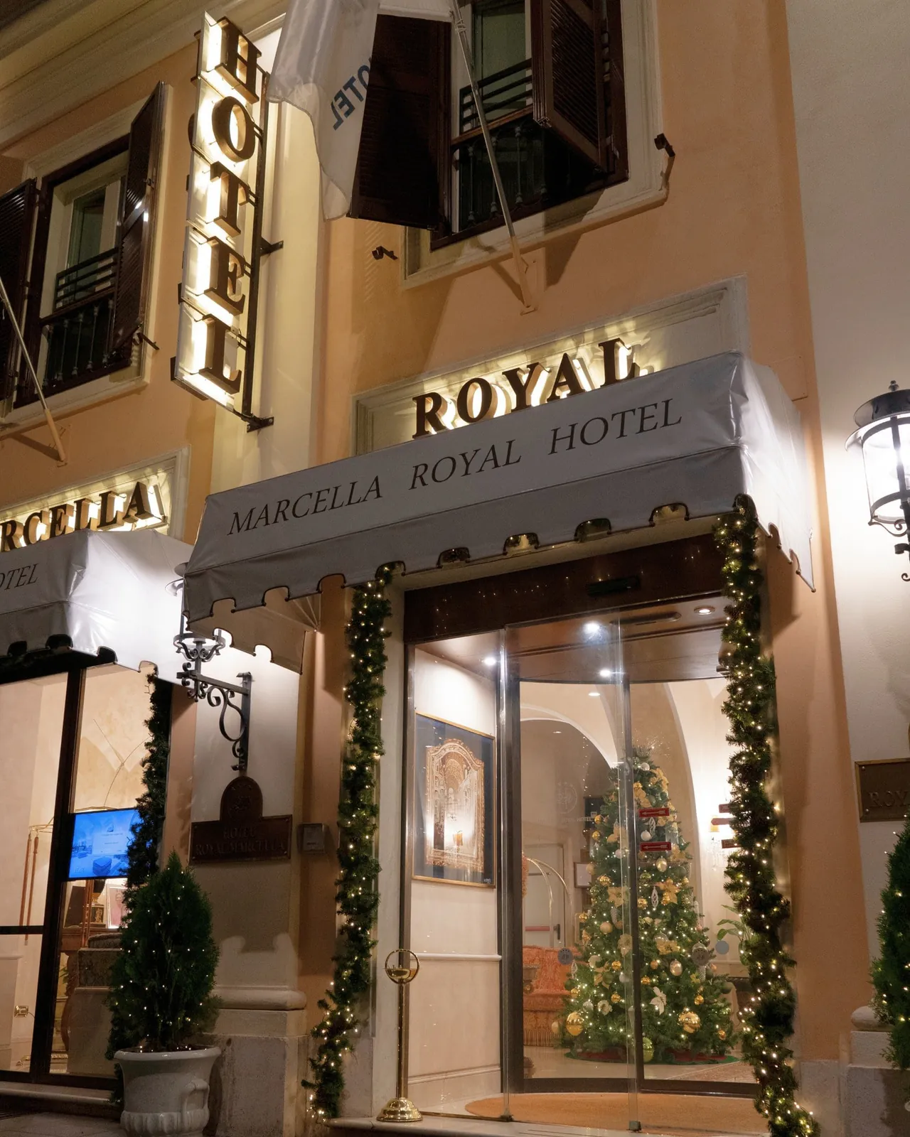 The lantern-lit entrance of Marcella Royal Hotel on Via Flavia.