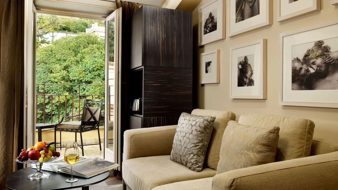 The Classic Suite living area with sofas, photo prints and an open balcony door.