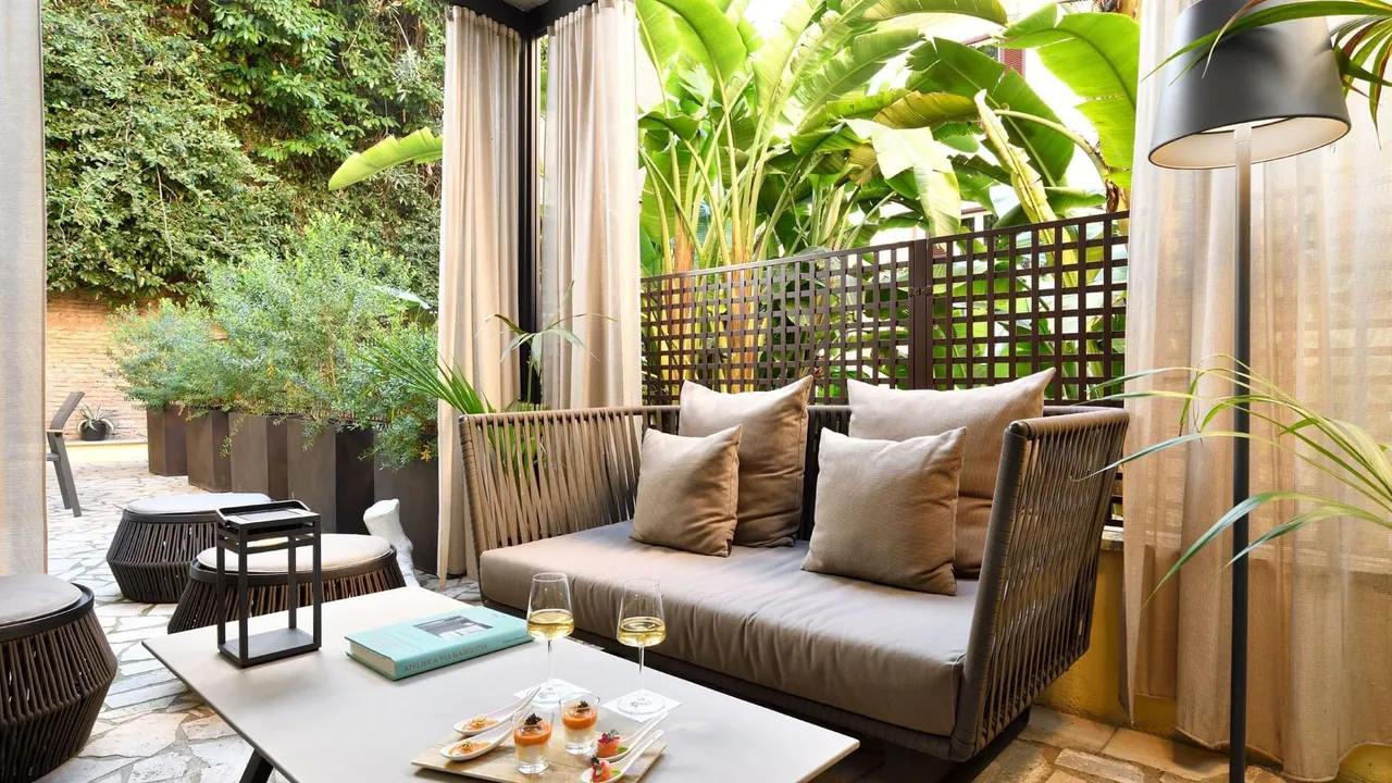 The covered garden lounge of a Garden Suite surrounded by palms and plants.