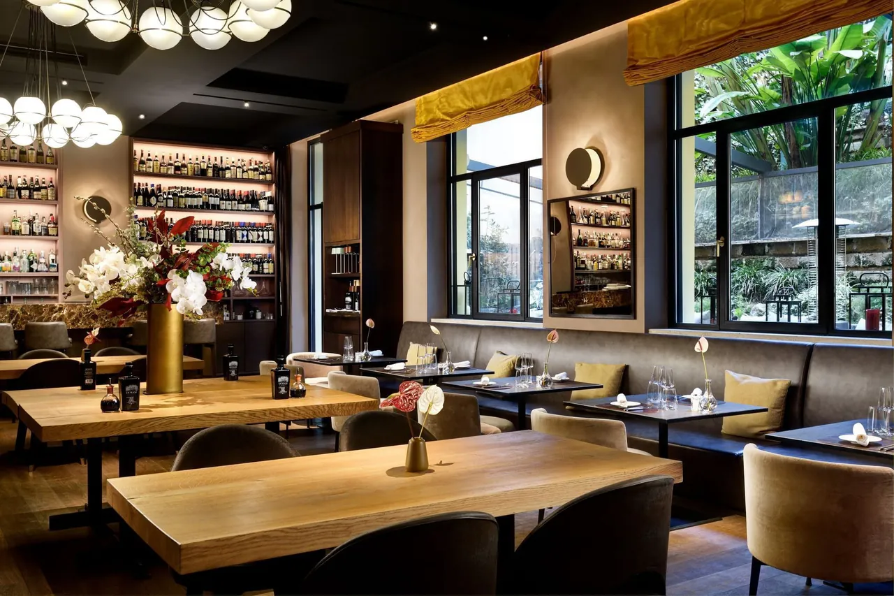 The EMME restaurant dining room with wooden tables and globe lights.