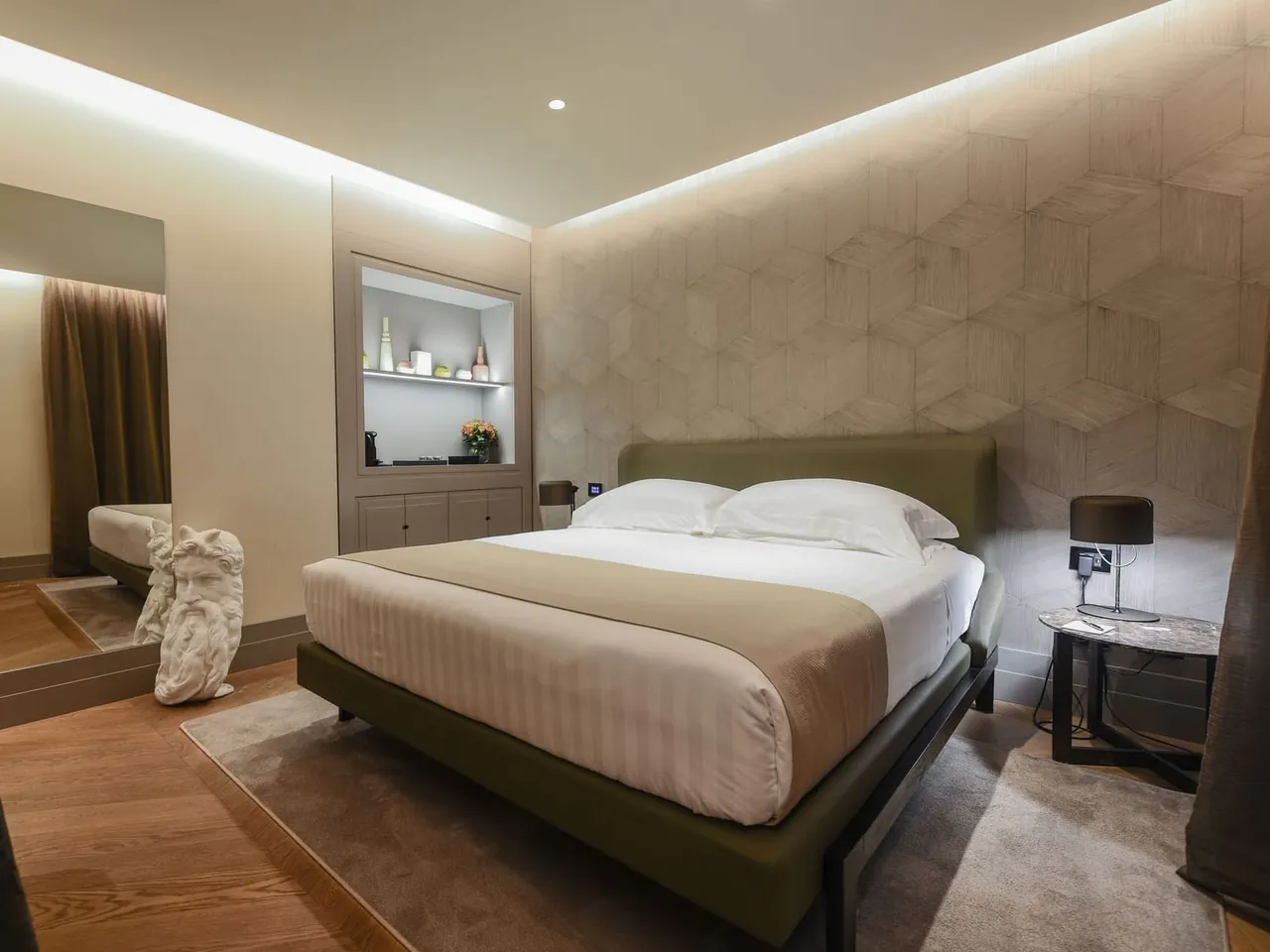 A calm Garden Suite bedroom in soft beige tones with a cove lit ceiling.