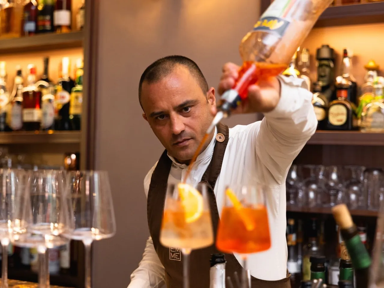 A bartender pouring a spritz at the hotel bar.