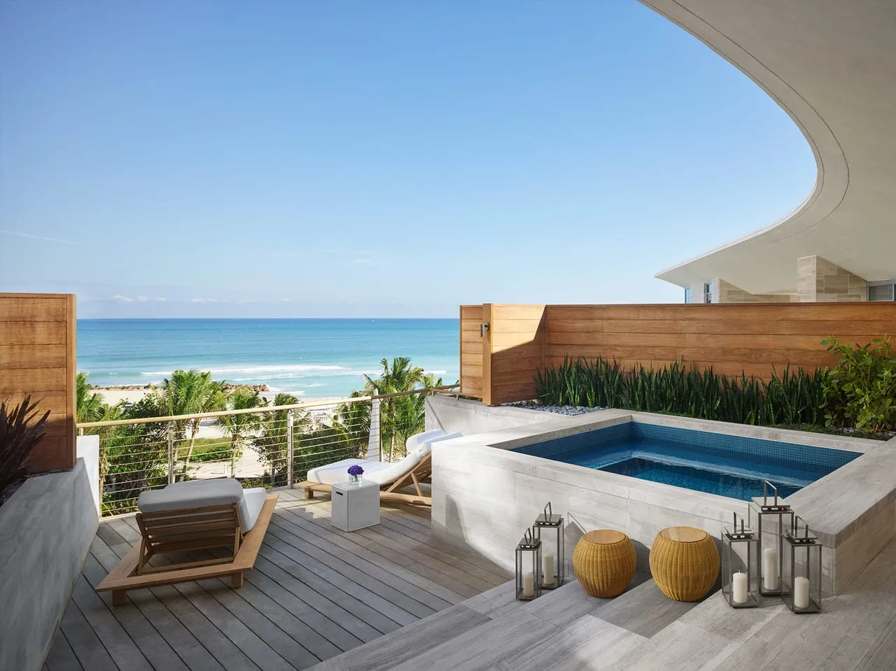 Private terrace at The Miami Beach Edition with a plunge pool, loungers and ocean views over palms