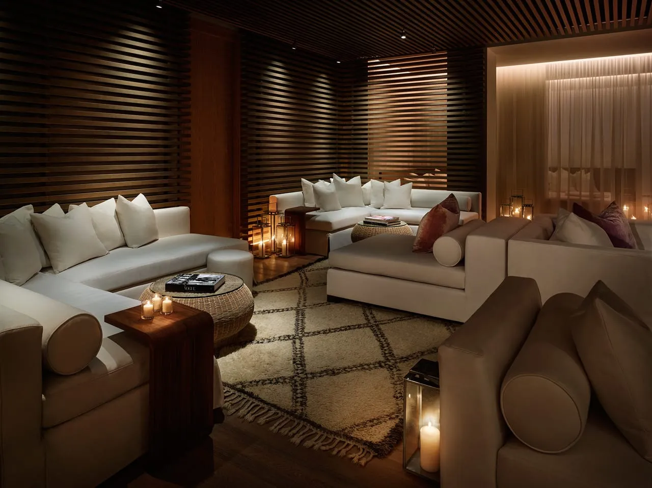 Candlelit lounge at The Miami Beach Edition with cream sofas, slatted wood walls and a patterned rug