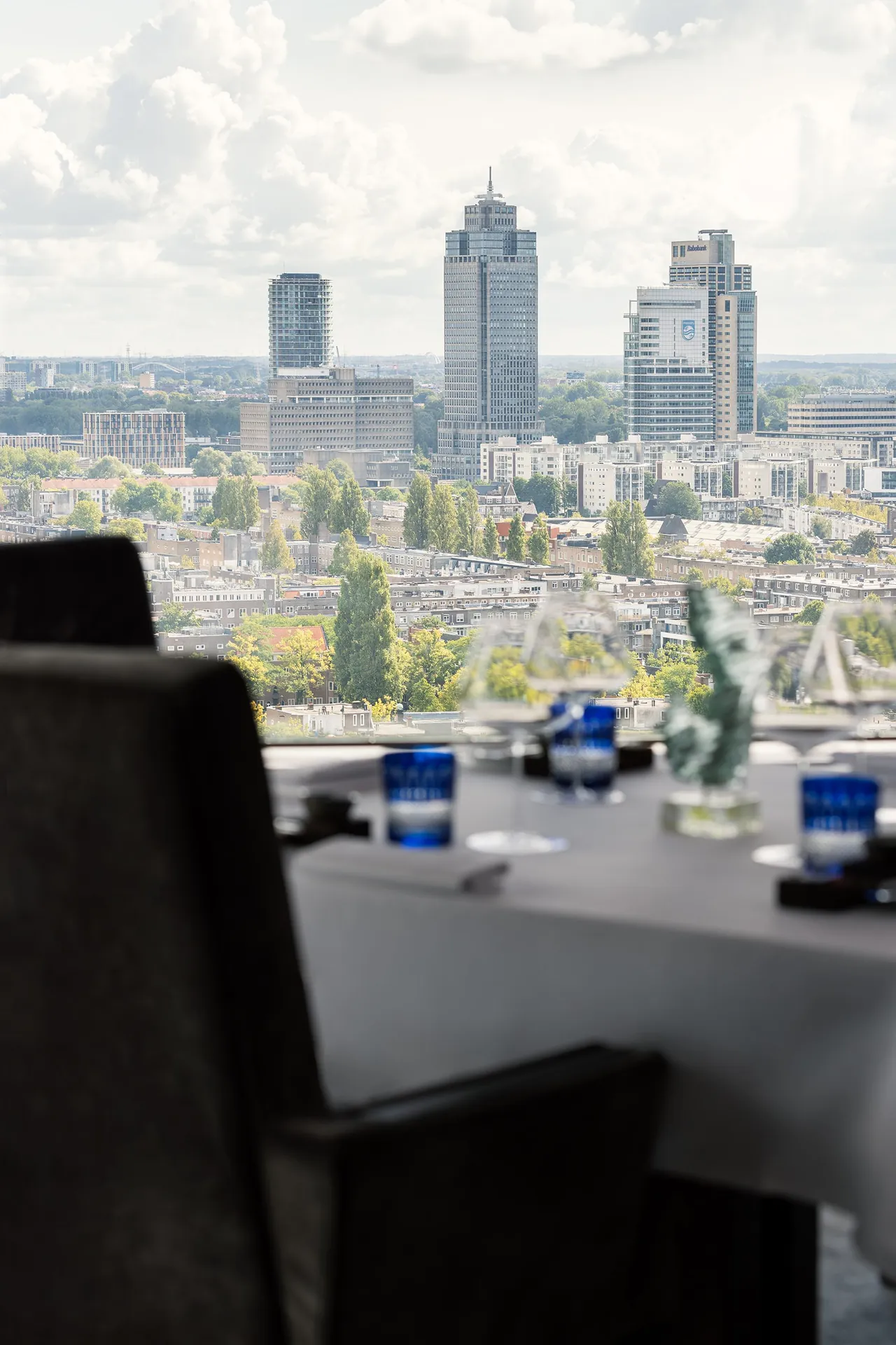 A desk by the window looks out over the Amsterdam skyline from high up.