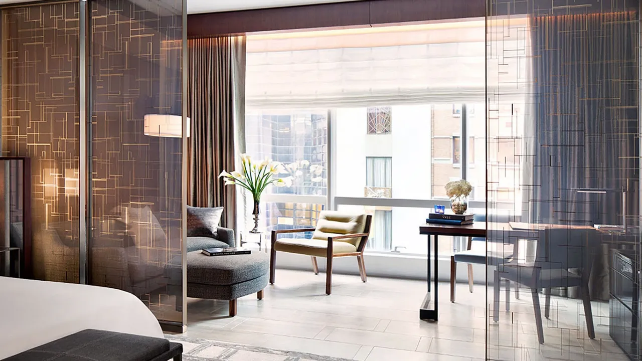 Room at Park Hyatt New York with patterned glass screens, a lounge chair and desk by a window