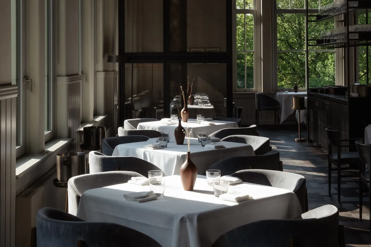 The restaurant with white tablecloths and large garden windows.