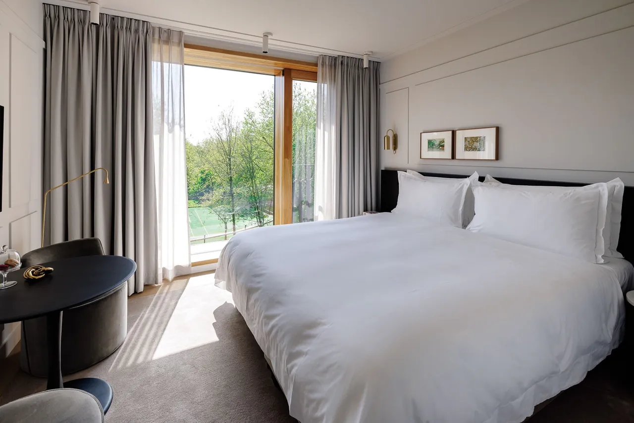 A bright guest room with a large window looking out over the park.