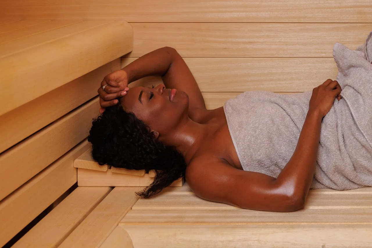 A guest resting on a wooden bench in the sauna.