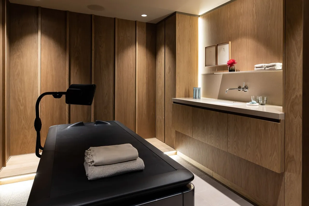 A wood-panelled spa treatment room with a massage table.