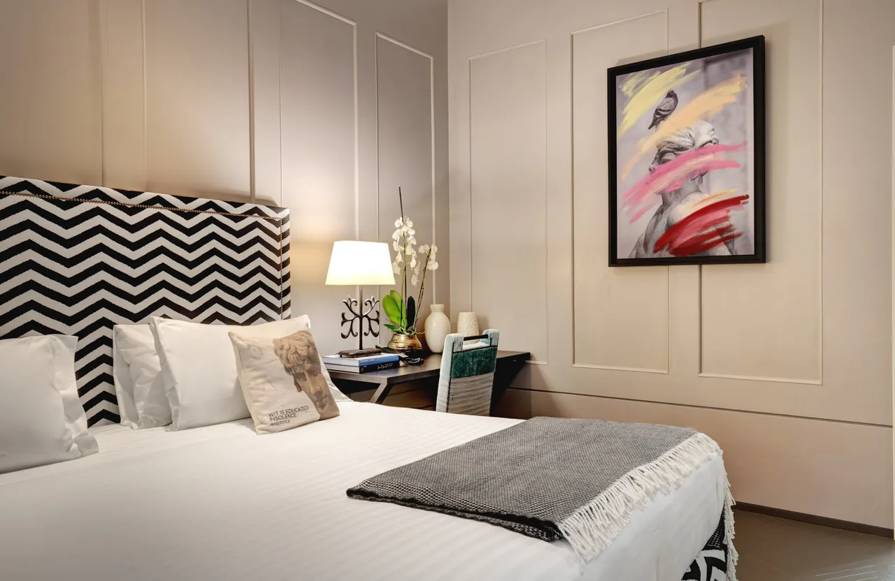 A family suite bedroom with a zigzag headboard and an abstract painting.