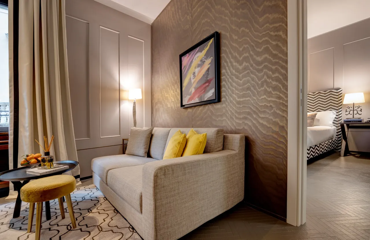 A cosy sitting corner with a pale sofa and yellow cushions beside the bedroom.