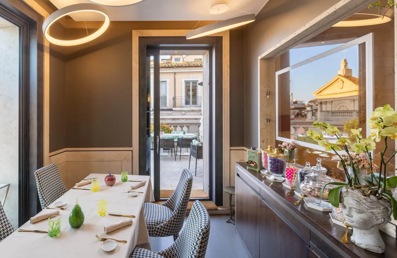 The rooftop restaurant with laid tables and a view of a golden dome.