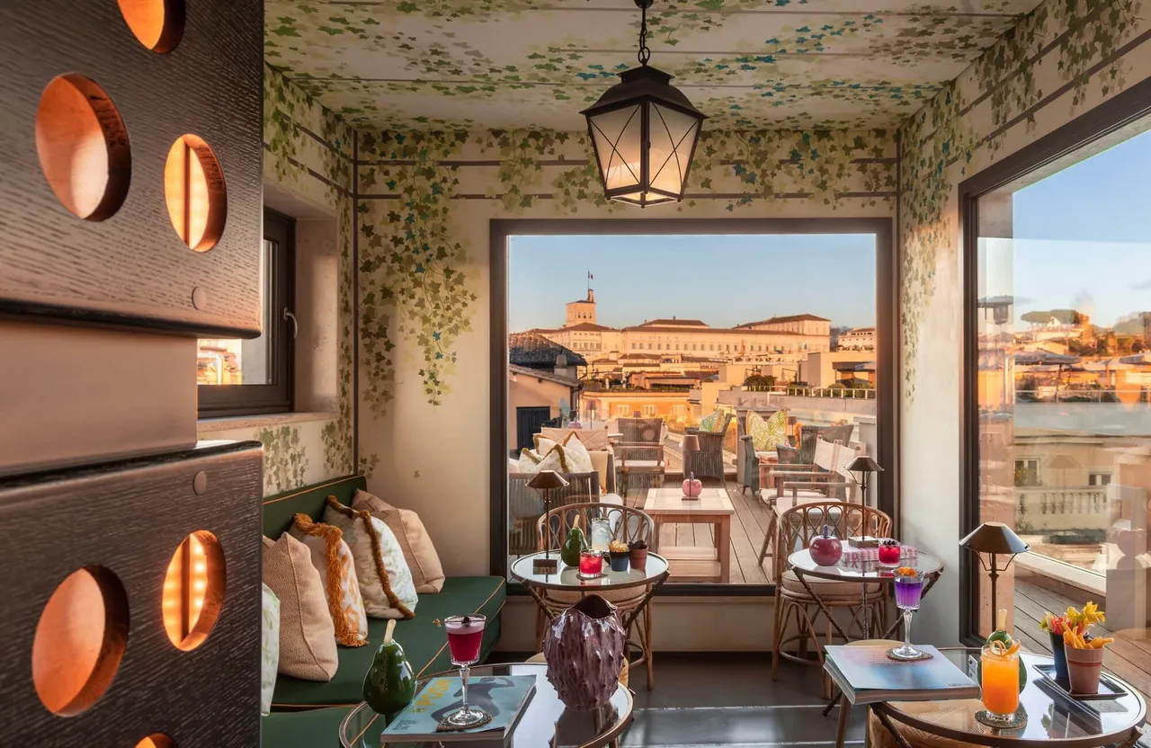 The rooftop bar with leafy painted walls and a wide window over Rome.