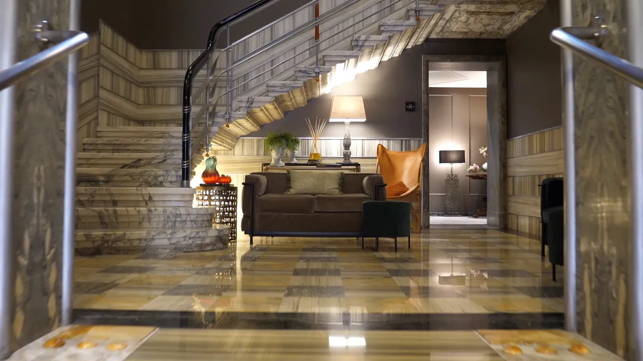 The marble lobby with its sweeping staircase and a lounge corner.